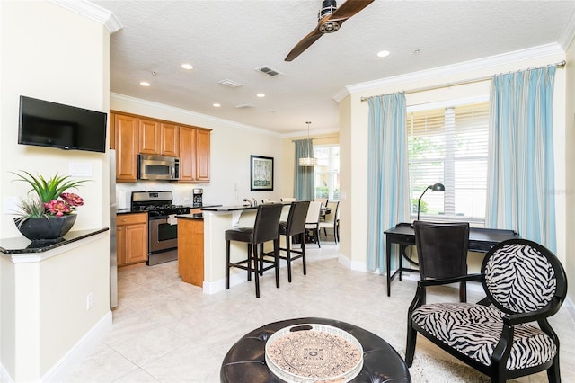 kitchen with crown molding, a textured ceiling, and stainless steel appliances