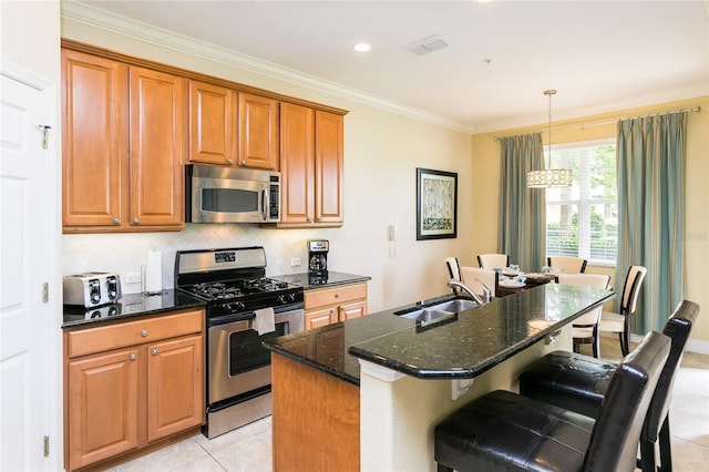 kitchen featuring a center island with sink, light tile patterned floors, appliances with stainless steel finishes, ornamental molding, and a notable chandelier