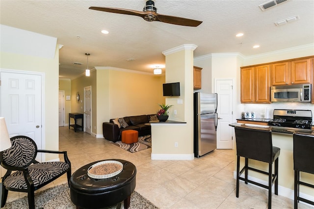 kitchen featuring a kitchen breakfast bar, ornamental molding, stainless steel appliances, and a textured ceiling