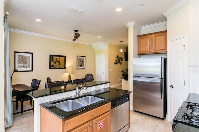 kitchen featuring an island with sink, a textured ceiling, dark stone counters, sink, and stainless steel appliances