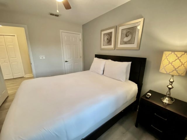 bedroom with dark hardwood / wood-style flooring, a closet, and ceiling fan