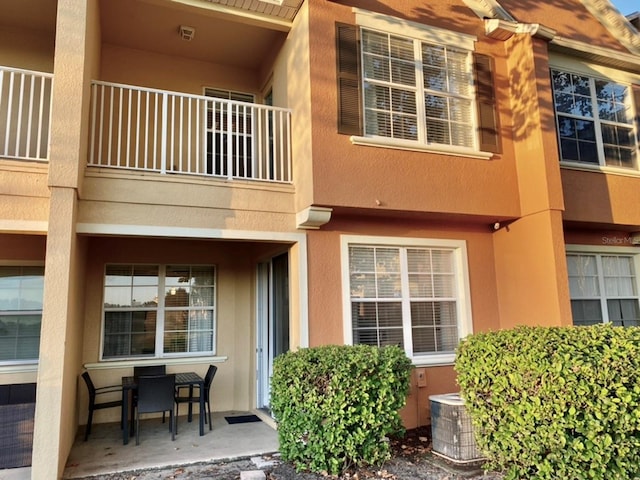 property entrance featuring a patio, a balcony, and central air condition unit