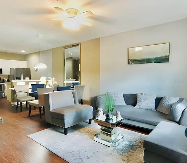 living room featuring ceiling fan and dark wood-type flooring