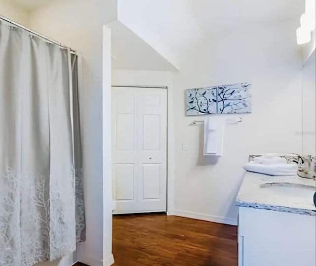 bathroom with lofted ceiling, wood-type flooring, and vanity