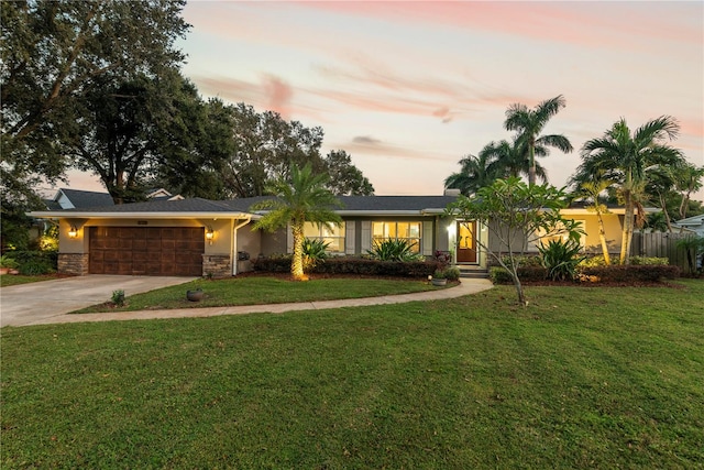 ranch-style home with a yard and a garage