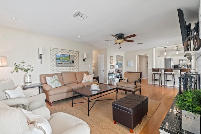 living room featuring light hardwood / wood-style floors and ceiling fan