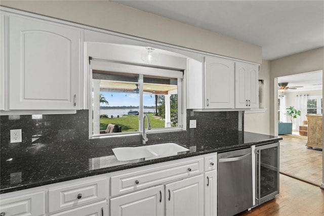 kitchen with white cabinetry, sink, and beverage cooler