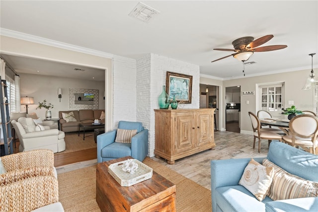 living room featuring ceiling fan, crown molding, and light wood-type flooring