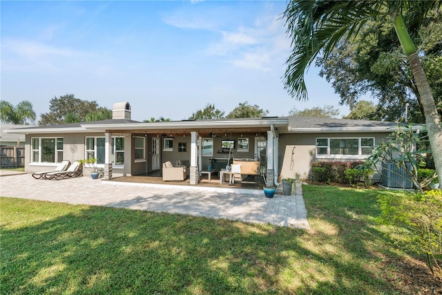 rear view of house with a patio area and a lawn