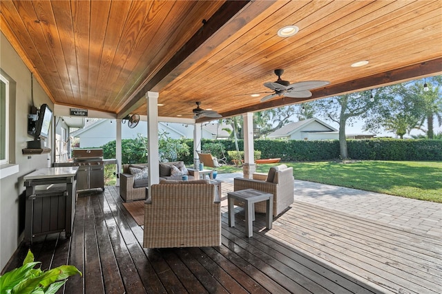 wooden deck with an outdoor hangout area, a lawn, and ceiling fan