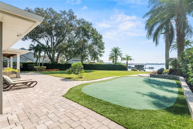 view of community featuring a patio area, a yard, and a water view