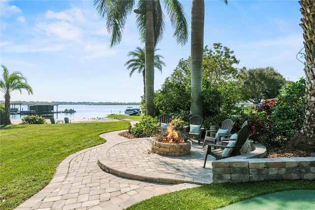 exterior space with a patio, a fire pit, a yard, and a water view