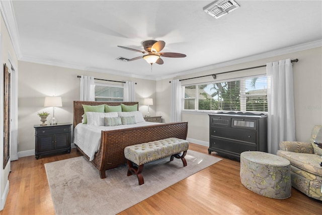 bedroom featuring ceiling fan, ornamental molding, and light hardwood / wood-style flooring