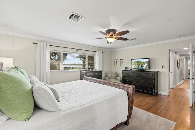 bedroom featuring crown molding, dark hardwood / wood-style floors, and ceiling fan