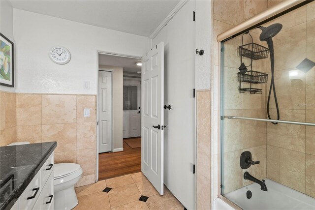 full bathroom featuring enclosed tub / shower combo, toilet, ornamental molding, vanity, and tile patterned flooring