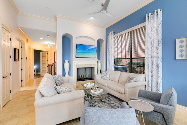 tiled living room with ceiling fan and crown molding