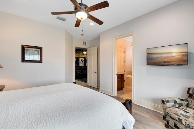 bedroom with light hardwood / wood-style floors, ensuite bath, and ceiling fan