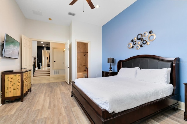 bedroom featuring connected bathroom, light hardwood / wood-style floors, and ceiling fan