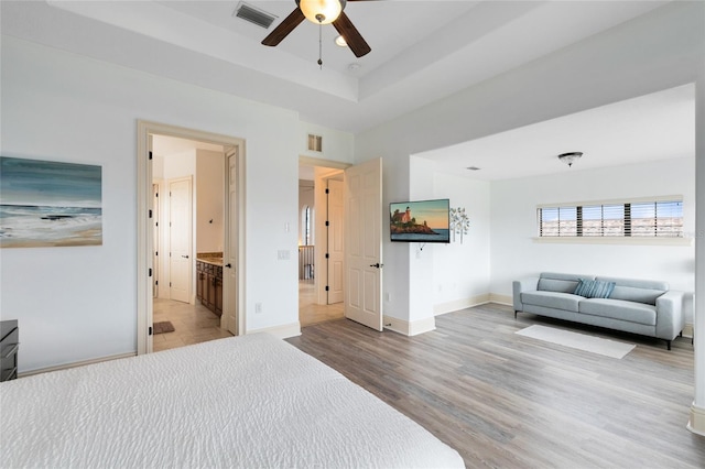 bedroom featuring connected bathroom, ceiling fan, and light hardwood / wood-style floors