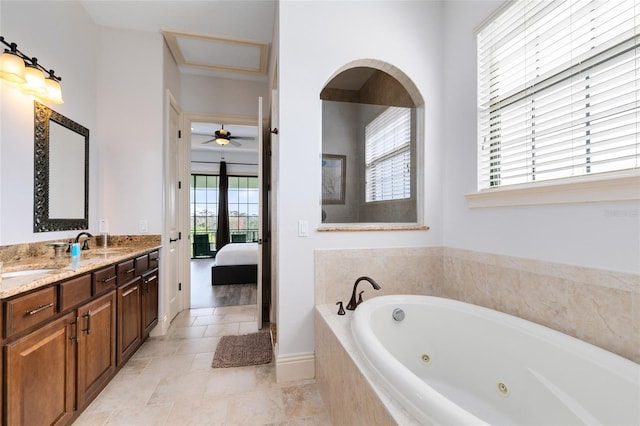 bathroom with vanity, plenty of natural light, and tiled tub