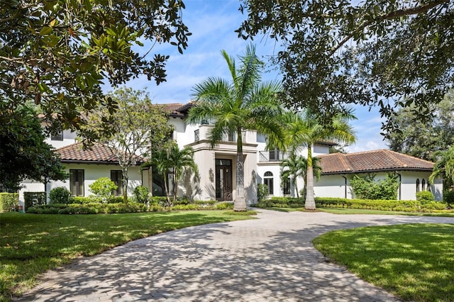 mediterranean / spanish-style house featuring a front lawn