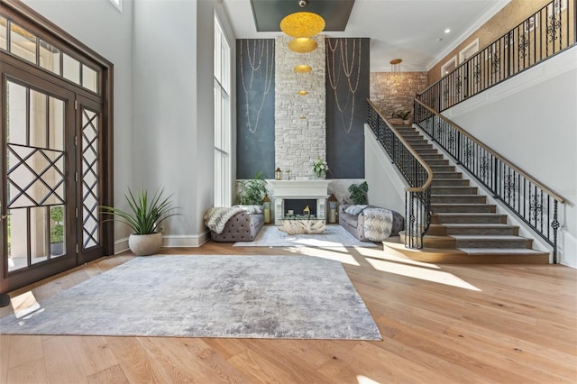 foyer entrance with crown molding, hardwood / wood-style flooring, and a towering ceiling