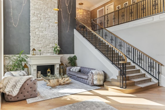 interior space with crown molding, a towering ceiling, and hardwood / wood-style floors