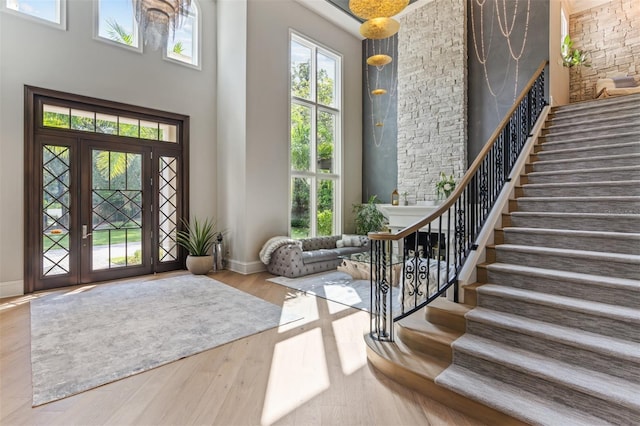 entryway featuring light hardwood / wood-style floors, a wealth of natural light, and a high ceiling