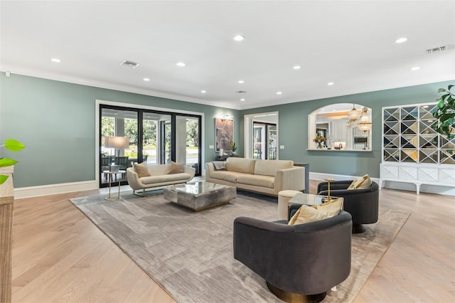 living room featuring crown molding and light hardwood / wood-style flooring