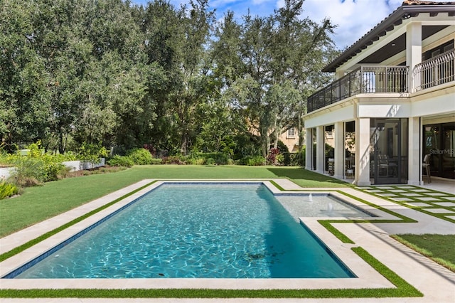 view of pool with a patio and a lawn