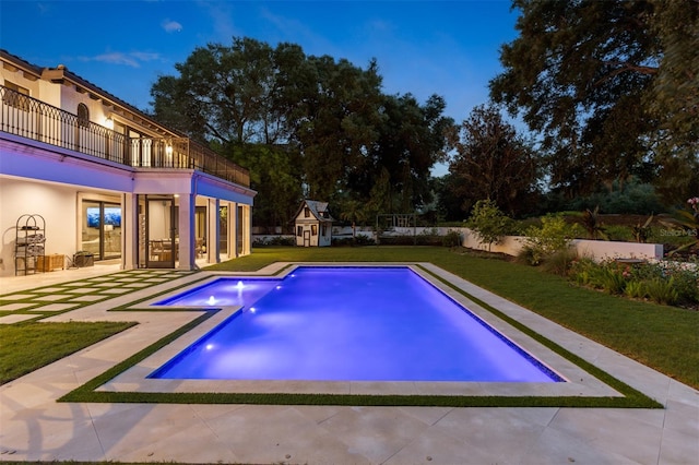 view of swimming pool featuring a patio area and a yard