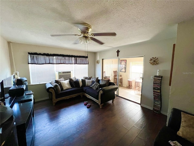 living room featuring cooling unit, ceiling fan, hardwood / wood-style floors, and a textured ceiling