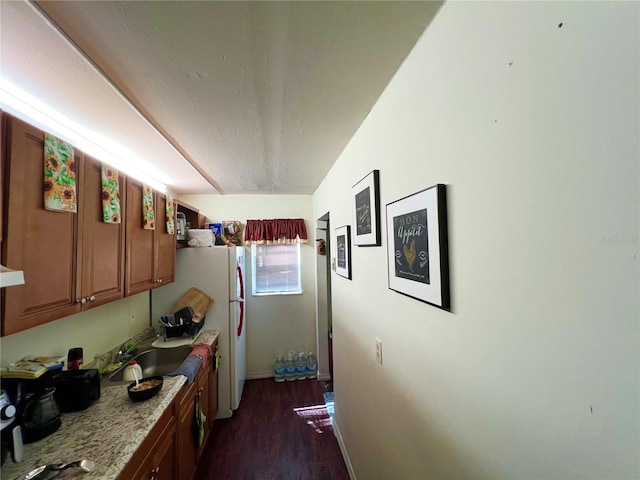 kitchen with light stone countertops, dark wood-type flooring, sink, and exhaust hood