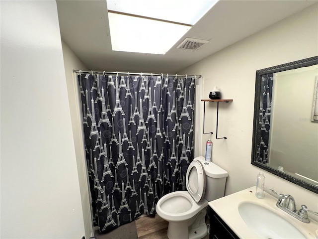 bathroom featuring wood-type flooring, a shower with shower curtain, vanity, and toilet