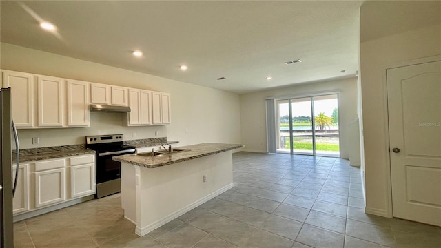 kitchen with white cabinets, an island with sink, appliances with stainless steel finishes, and dark stone counters