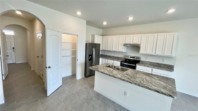 kitchen featuring a kitchen island with sink, sink, stainless steel appliances, light tile patterned floors, and white cabinetry