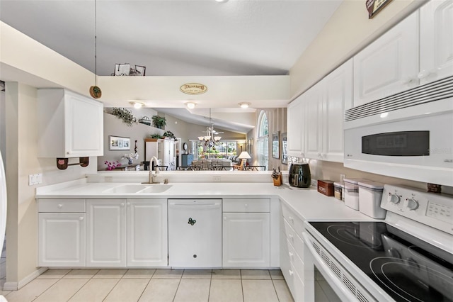 kitchen with white cabinets, vaulted ceiling, pendant lighting, sink, and white appliances