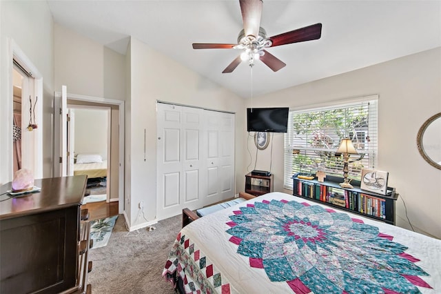 bedroom with vaulted ceiling, carpet floors, a closet, and ceiling fan