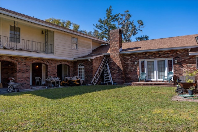 back of property featuring a patio, french doors, a lawn, and a balcony