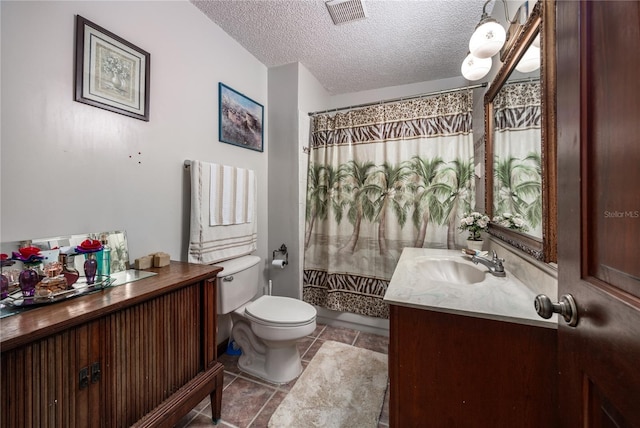 bathroom featuring vanity, a textured ceiling, and toilet