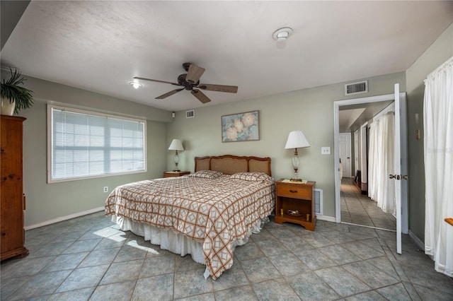 tiled bedroom featuring ceiling fan