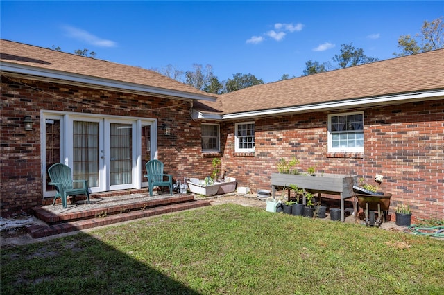 back of property with french doors and a yard