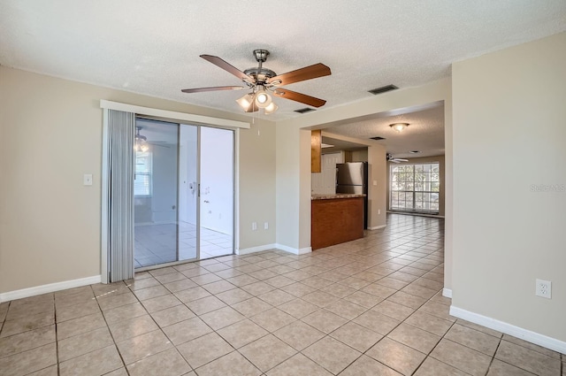 tiled empty room with a textured ceiling