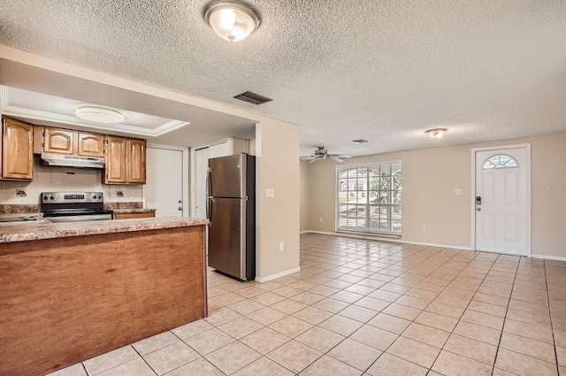 kitchen with a textured ceiling, tasteful backsplash, ceiling fan, light tile patterned flooring, and appliances with stainless steel finishes