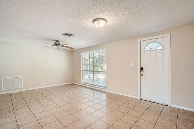 tiled foyer featuring a textured ceiling and ceiling fan