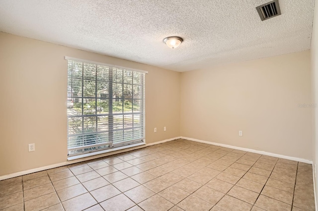 tiled spare room with a textured ceiling