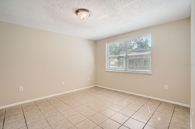 unfurnished room with a textured ceiling and light tile patterned floors