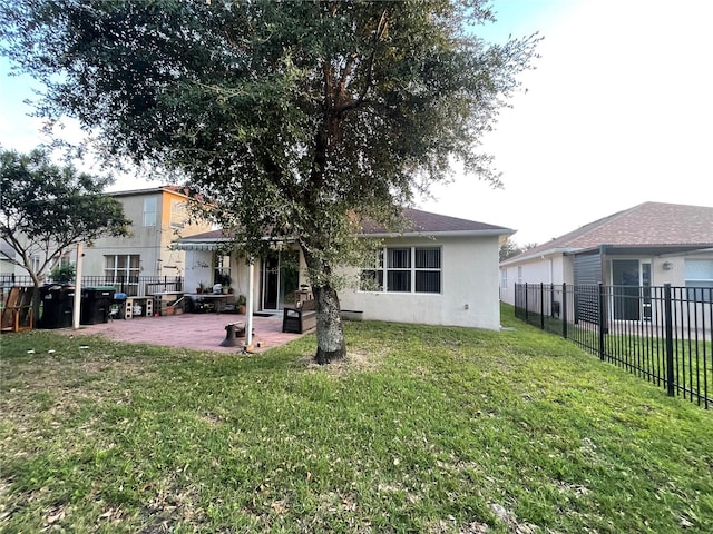 rear view of property featuring a lawn and a patio