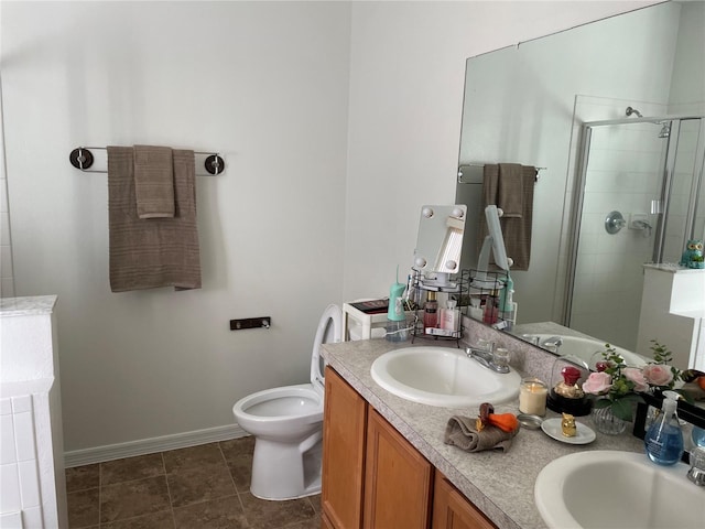 bathroom featuring tile patterned flooring, vanity, toilet, and a shower with door