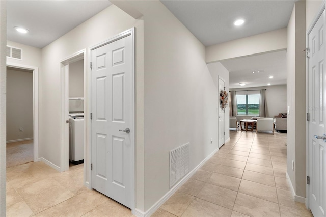 hall featuring light tile patterned flooring and washer / clothes dryer